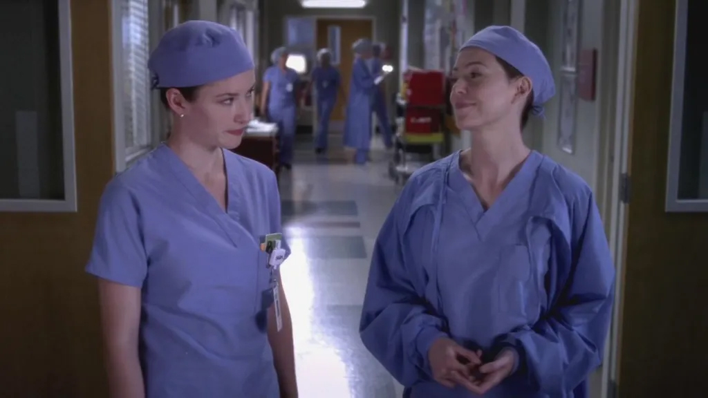 Still of Lexie (played by Chyler Leigh) and Meredith (played by Ellen Pompeo) wearing scrub caps and hospital scrubs from Grey's Anatomy