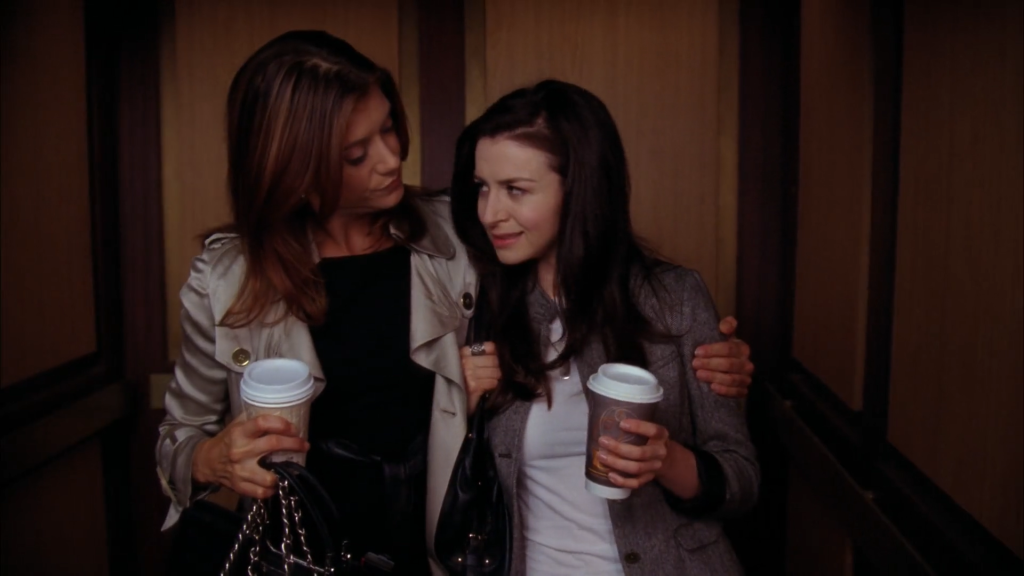 Still of Addison (played by Kate Walsh) with her arm around Amelia (played by Caterina Scorsone) holding coffee to-go cups in the elevator from Private Practice 4x05